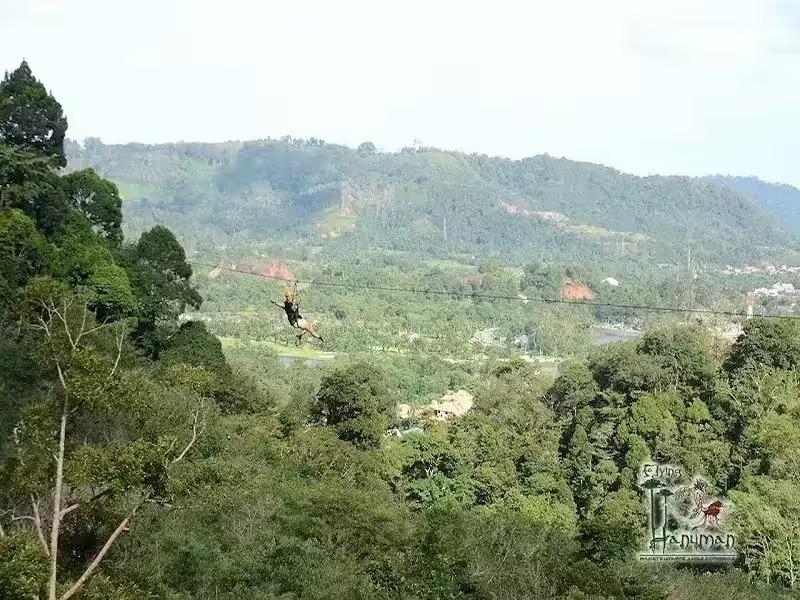 Adventurers on a long zipline through the lush green canopy at Hanuman World Phuket